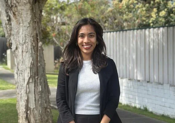 Master of International Relations Deakin student Shehara standing outside next to a tree, smiling at the camera.