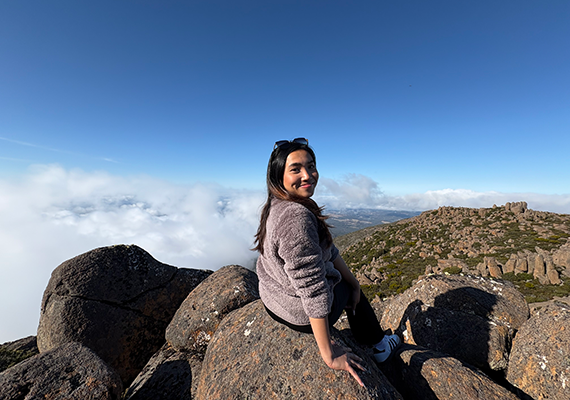 Bianca Marie Ines Nieves sitting on a rock