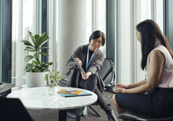 Two health professionals review data in a corporate meeting.