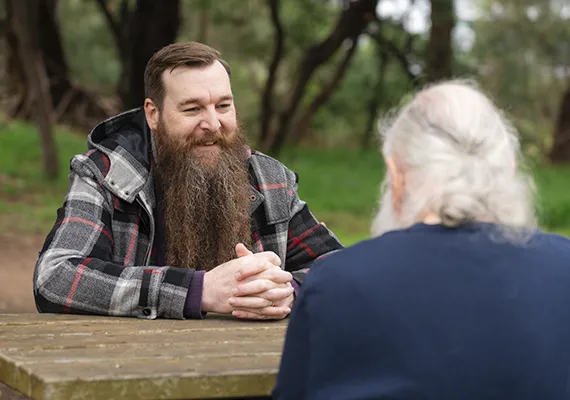 Al Fricker facing Bryan Fricker on picnic table
