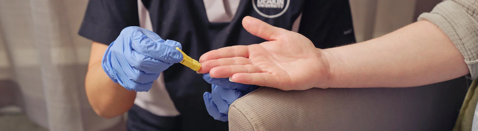 A Deakin postgraduate diabetes education student pricks a finger.