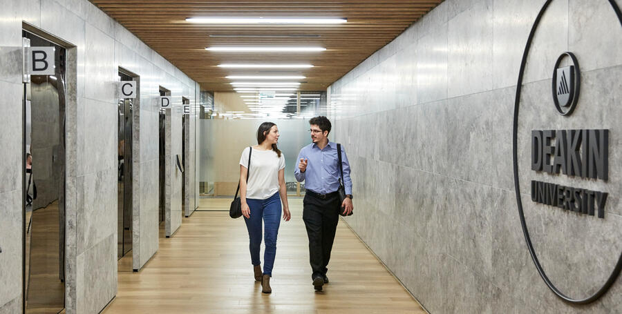 Two Deakin University professionals walking from the lifts at Melbourne Downtown Corporate Centre. 