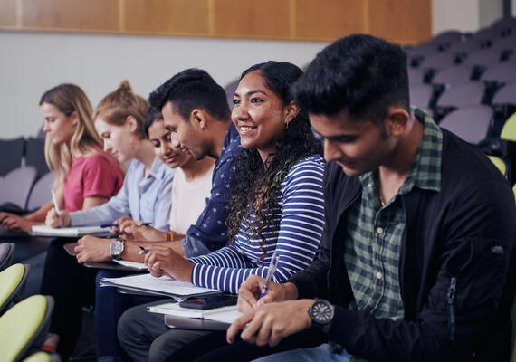 Deakin international students taking notes in a lecture.