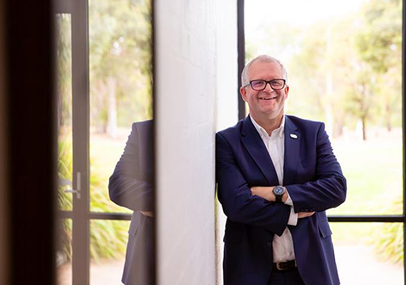 Professor Iain Martin standing in front of a window