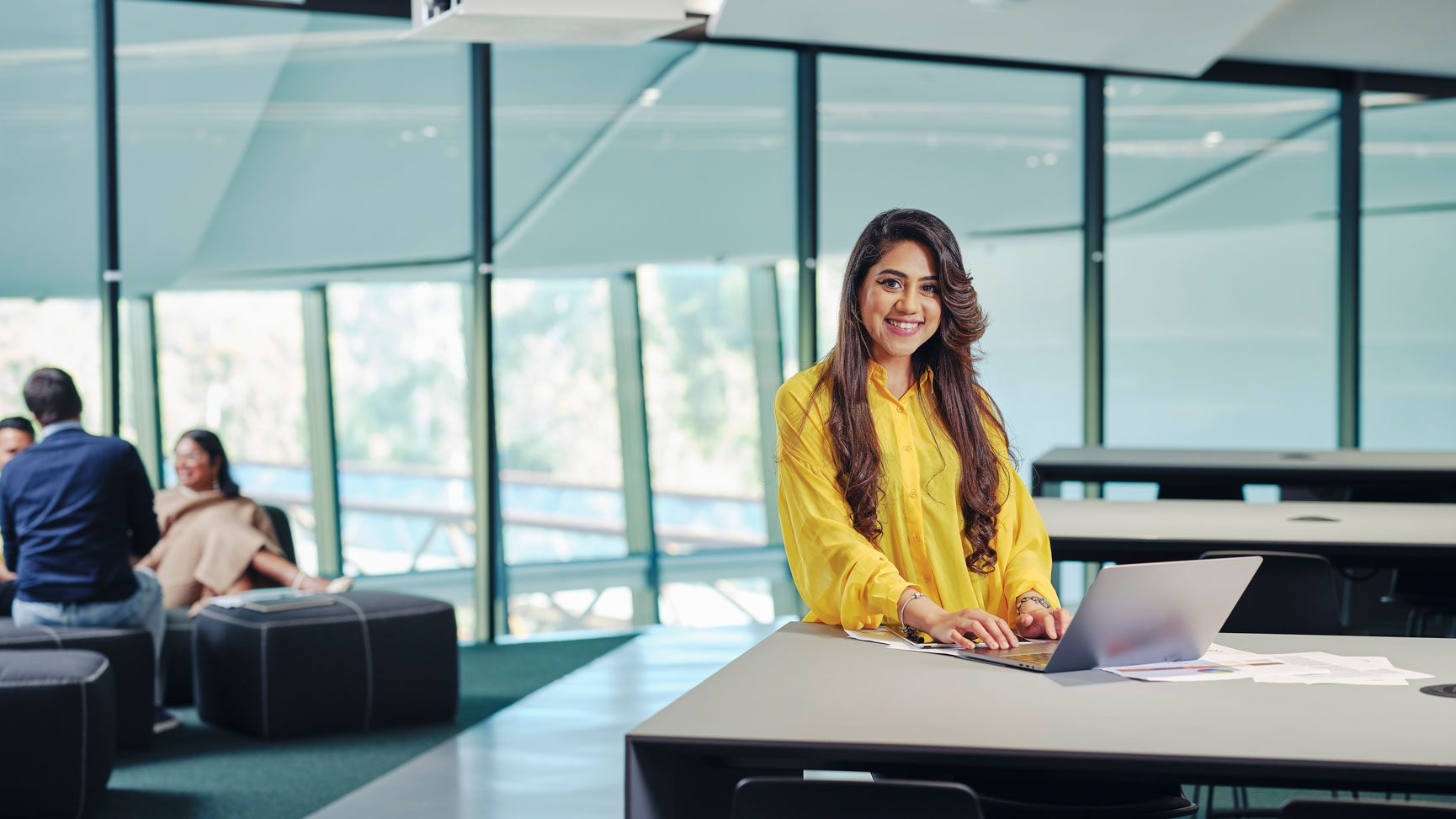 Image of a student smiling while working on a laptop at Deakin Burwood