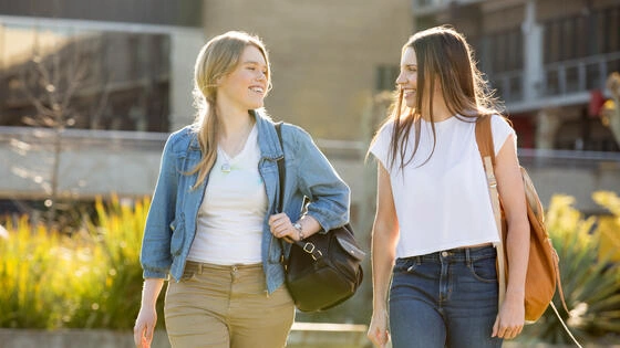 Two Deakin arts students walk and chat.