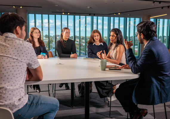 Students sit around a table having a discussion