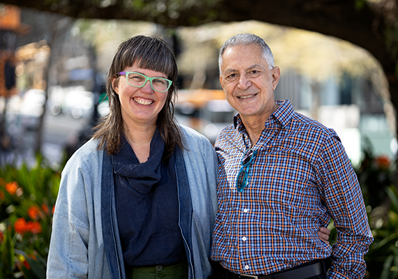 Dr Louisa Smith and Dr Dino Hodge standing next to each other in a park looking at the camera. 