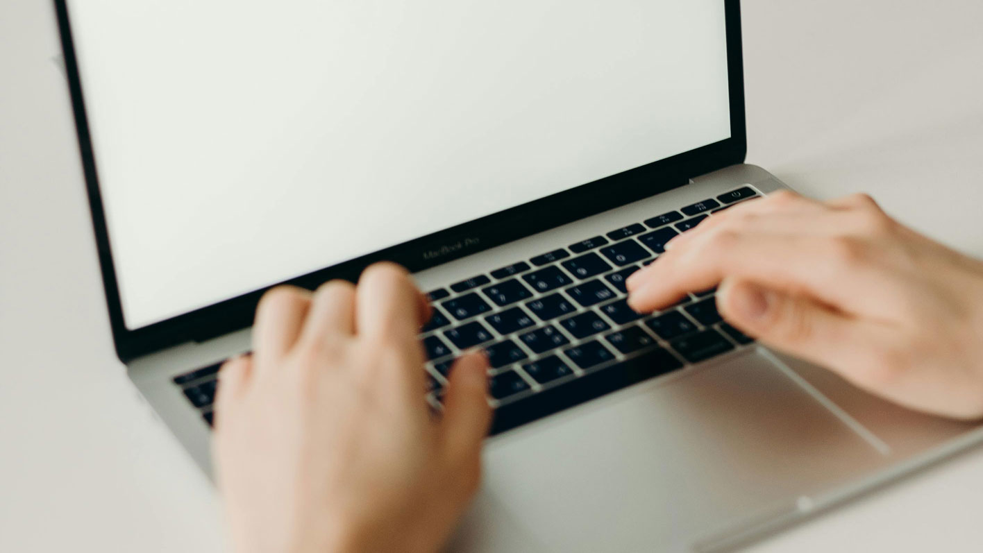 Image of hands typing on a laptop computer