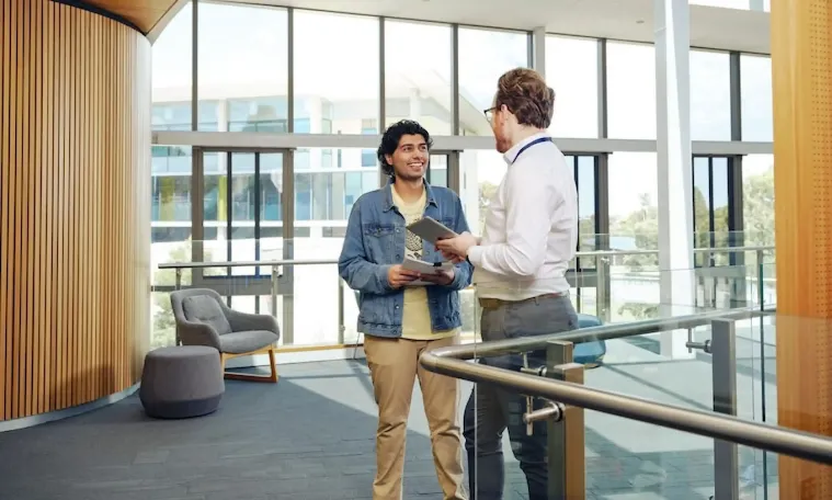 Two students standing and chatting