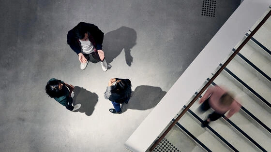 Three Deakin students standing and chatting. 