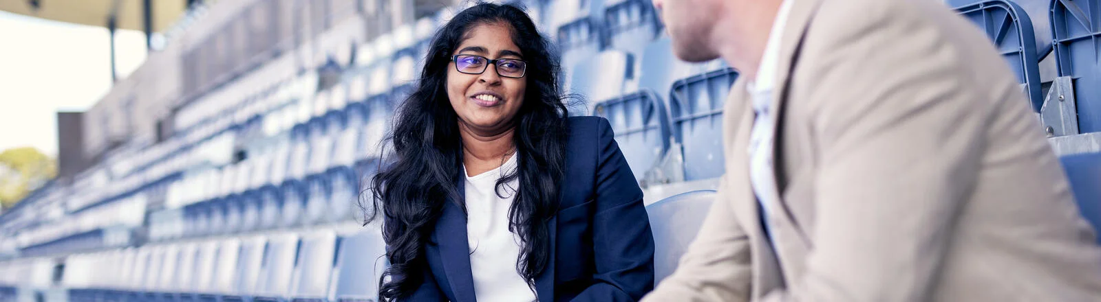 Two Deakin business students in grandstands at Parkville Sports Centre.