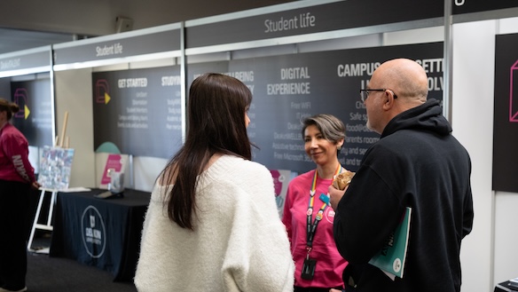A Deakin staff member chatting to a parent and student about courses at Open Day