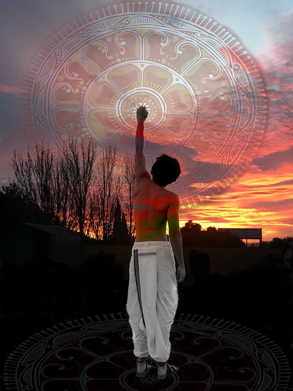 Photographic image of a young man with his back to the viewer, raising his fist to the sky, behind him is a sunset and the silhouette of trees and a large sign in the distance, a transparent circular image of traditional Indian artwork meets the centre of the young man's fist. He is in traditional Indian clothing, his back is exposed.