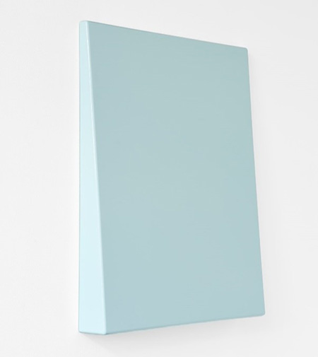 2023_Text_ReRead_Idiens.jpg A sculpture of a blue wedge on a white wall
