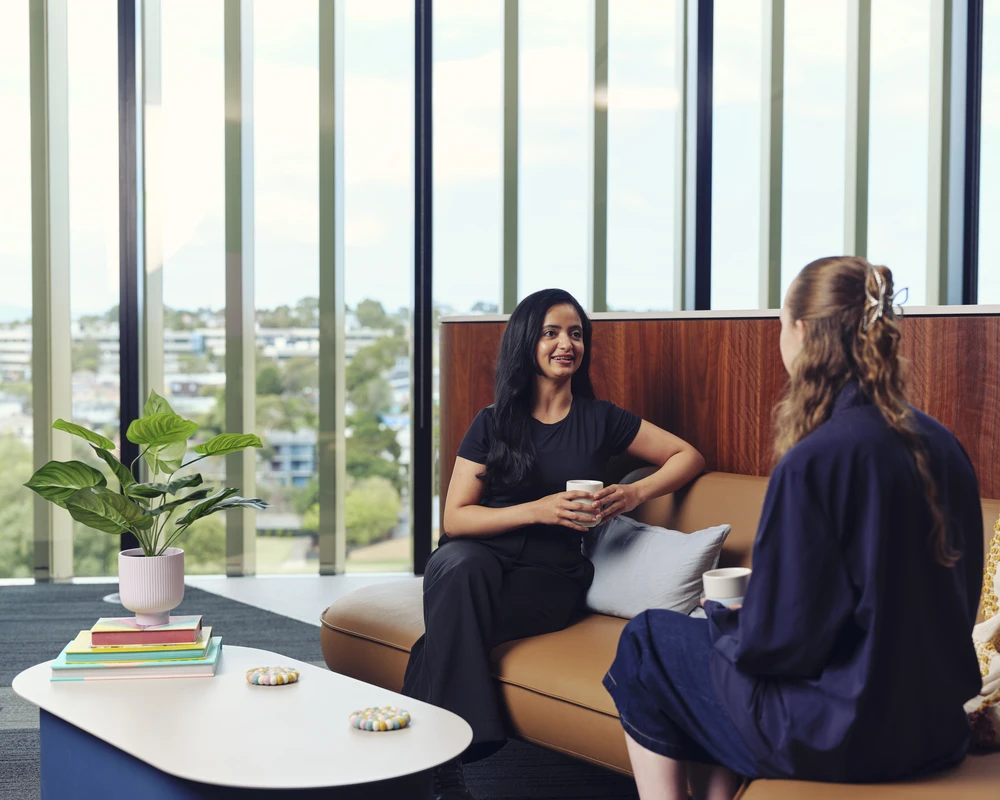 Two women talk while sitting on couches at Burwood Campus