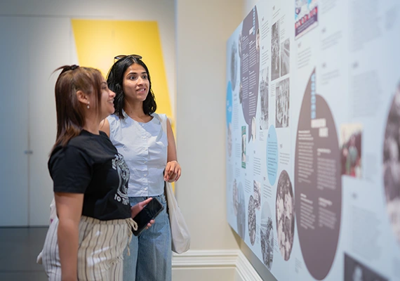 Two study abroad and exchange students talking in an art display.