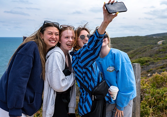 A group of summer school students taking a photo along the Great Ocean Road.