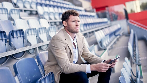 A Deakin Executive Graduate Certificate of Sport Business student sits in the grandstands.