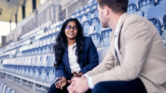 Two Deakin business students in grandstands at Parkville Sports Centre.