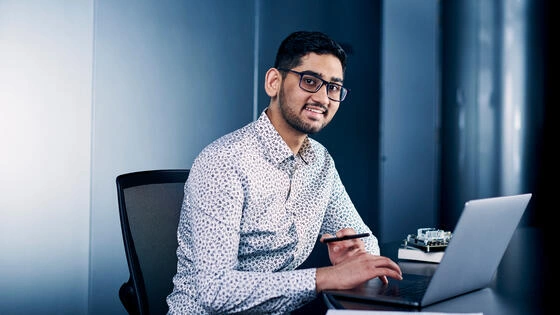 A Deakin postgraduate information technology management student works on a laptop.