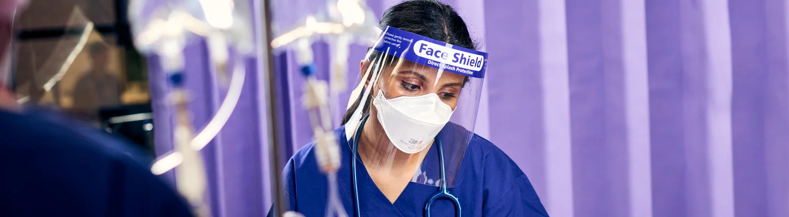 A Deakin postgraduate intensive care nursing student in PPE attends to a patient.