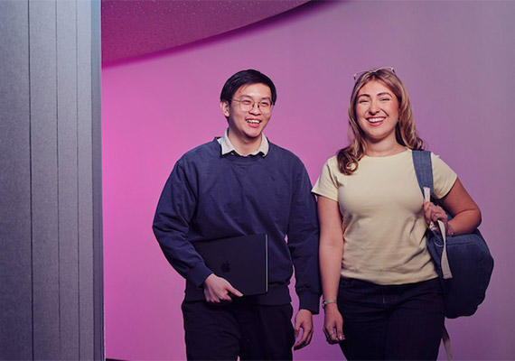 Two students walking in a building a Deakin