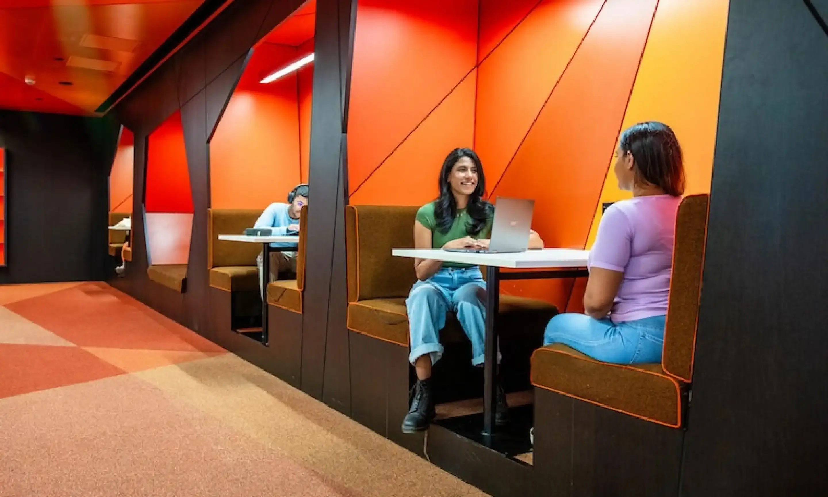 Two students studying in red booth