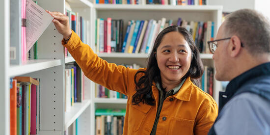 A professor and a researcher looking at books.